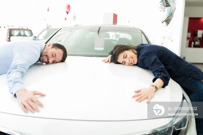 Smiling Man And Woman Hugging Their First Car