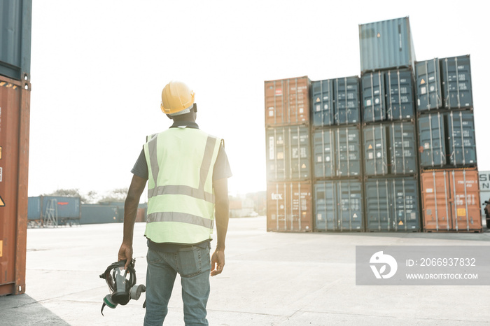 male factory worker or engineer holding gas mask and looking something in containers warehouse storage