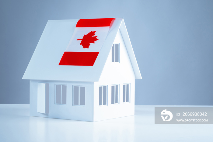 Model cottage with the flag of Canada. Acquisition of real estate in Canada. Moving to Ottawa. Real estate prices abroad. Moving to another country.