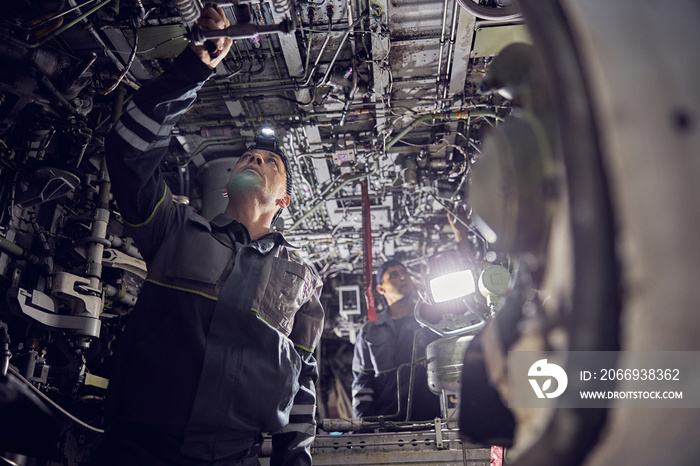 Aircraft worker repairing airplane in the indoors