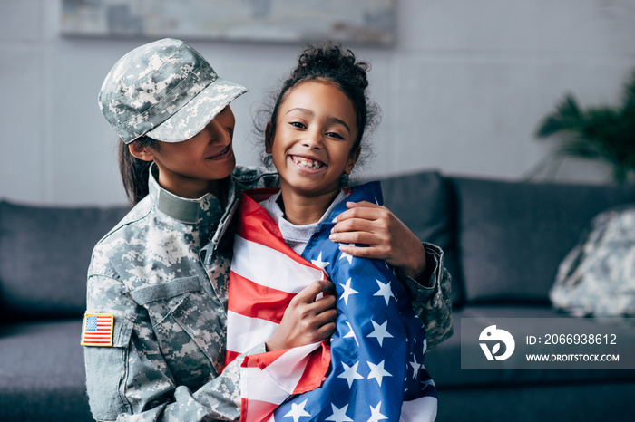 soldier and daughter wrapped with american flag