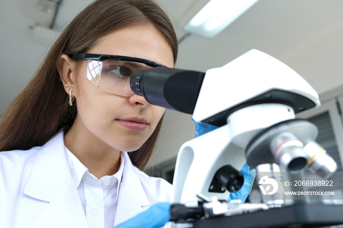 Cientist, she looks through the camera to see the details and Experiments with chemicals in the laboratory to create a vaccine for the treatment of diseases