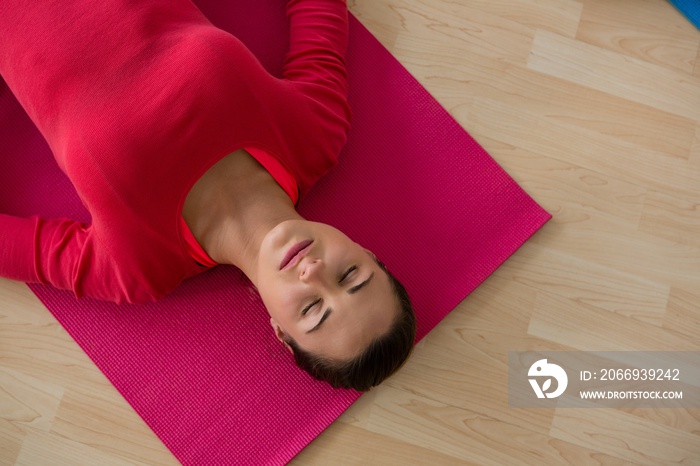 High angle view of woman exercising while lying on mat in yoga