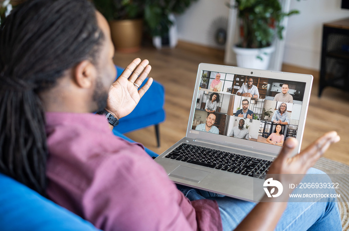 African guy taking a part in online webinar, video conference, talking and discussing with a group of diverse multiracial participants on screen. Male employee involved morning meeting on the distance