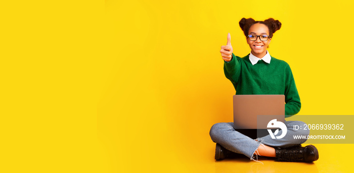 Happy afro teenager isolated over yellow studio background