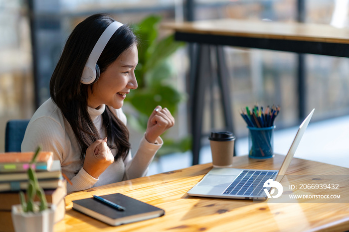 study abroad Asian girl wearing headphones watching laptop while doing homework video calling abroad using friend internet connection business women use computers to analyze financial data