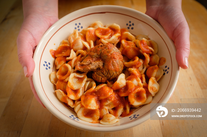 Typical Apulia region Sunday main course: fresh pasta orecchietta and meat roll braciola with tomato sauce