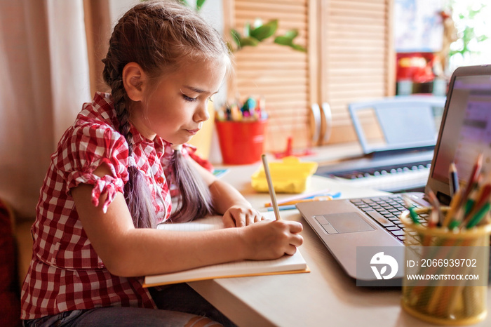 Distant education, back to school. Girl studying homework during online lesson at home