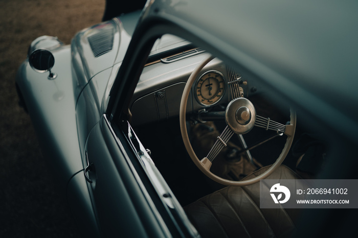 Oldtimer car dashboard. Retro car interior. Old steering wheel detail.