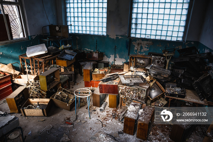 Group of old antique retro television or broken TV boxes in dark creepy abandoned house among garbage in dirty room