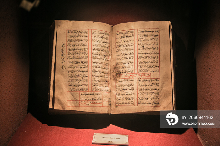 Old ancient quran (islam holy book) on red light. hand written Koran from 19.century