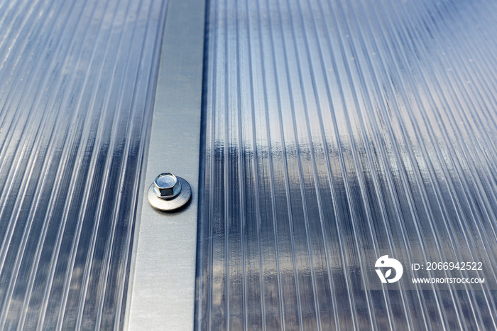 Polycarbonate greenhouse, fixing metal arcs with screws. Compound polycarbonate plastic sheet and frame