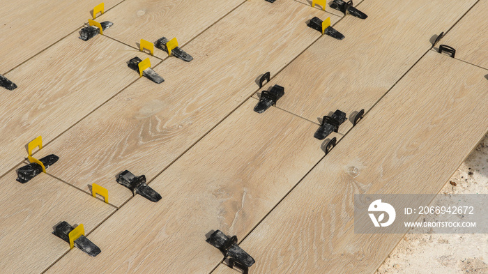 Pose de carrelage sur ancienne terrasse avec croisillons pour stabiliser les dalles