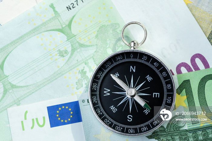 Europe economy direction, financial, investment or impact of brexit concept, compass put beside Europe map and Euro flag on Euro banknotes