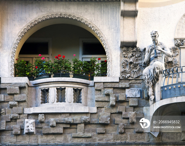 Art nouveau building facade with faun playing flute