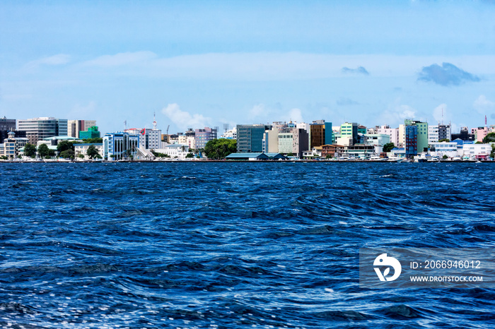 Beautiful tropical blue ocean and the skyline of Malé city in Maldives islands shot from speedboat