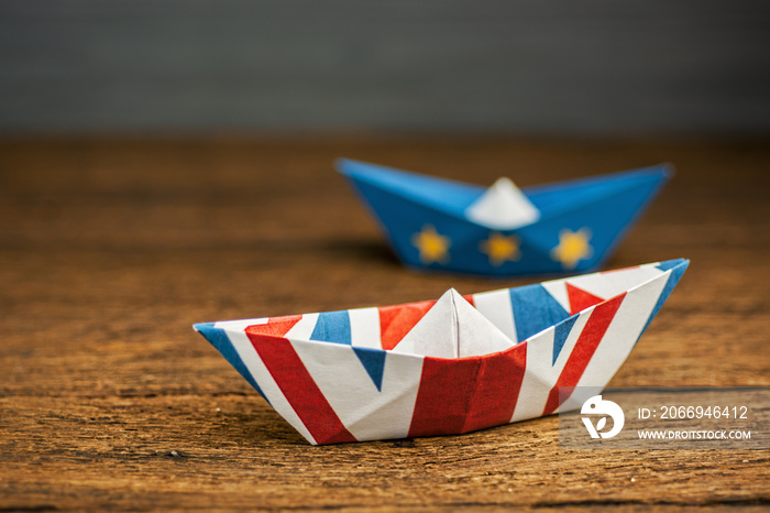 Brexit UK EU concept - paper ships from the flags of the European Union and the UK on a blue background