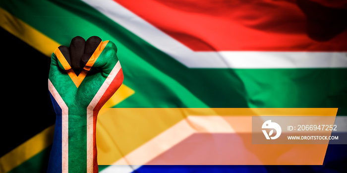 Banner of Flag of South Africa painted on male fist, fist flag, country of South Africa, strength, power, concept of conflict. On a blurred background