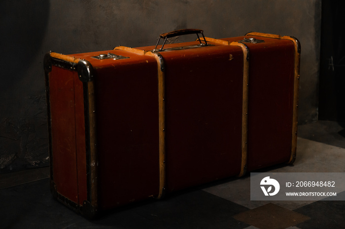 Old style vintage suitcase. Retro brown case in loft style room. Details of antique bag. Travel concept