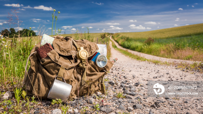 Vintage backpack with books, map and mug