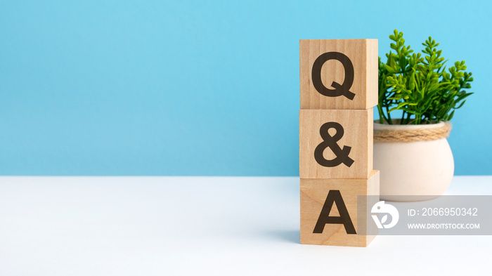 Q AND A - acronym from wooden blocks with letters, questions and answers. concept on grey background. copy space available