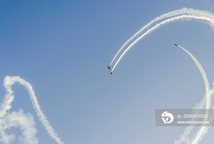 Aerobatic pilots with her colored airplanes training in the blue sky