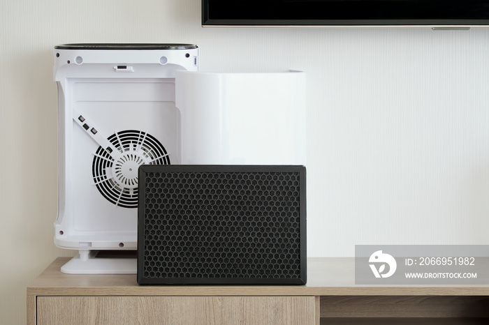 Air purifier and Hepa filter system placed on wooden cabinet, Backdrop of white wall with copy space, Living room and furniture decorated in minimalist style, Home electric appliances and Health care.