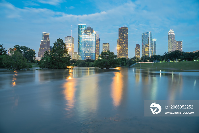 Reflection of Downtown Houston skyscrapers on a pond of overflow water from Bayou River to Eleanor Park after Harvey tropical storm. Heavy rain of hurricane Harvey caused many flooded areas in Houston