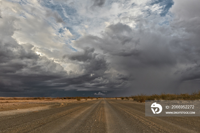 Gravel road with stormy sky, en route to the Namibia desert. Sossuvlei.