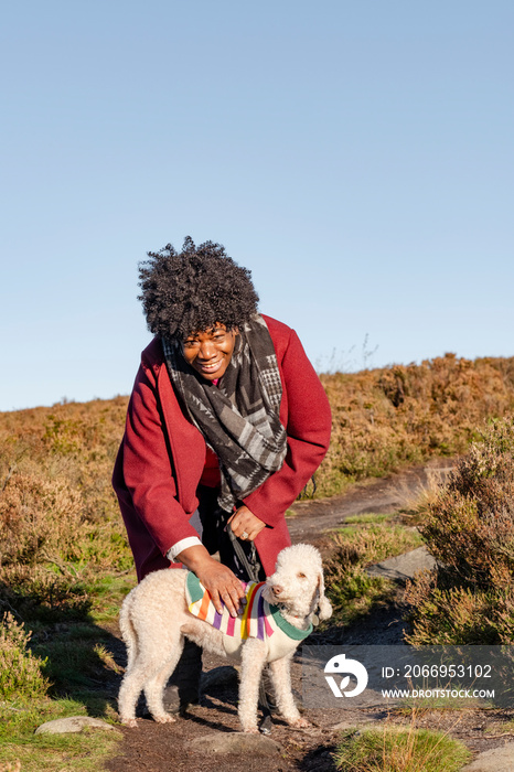 Senior woman with dog on footpath