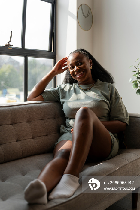 Portrait of young woman resting on sofa at home