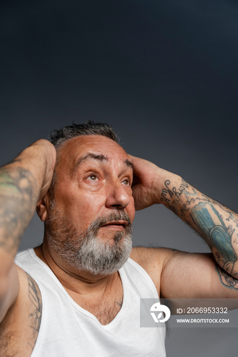 Portrait of man styling hair against gray background