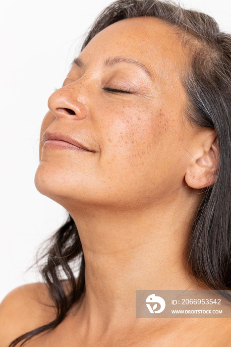 Studio portrait of smiling woman with eyes closed