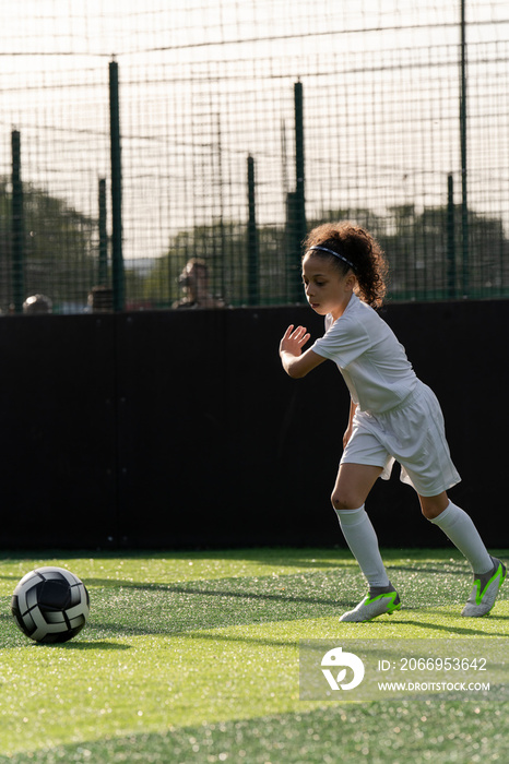 Girl (6-7) playing soccer on soccer field
