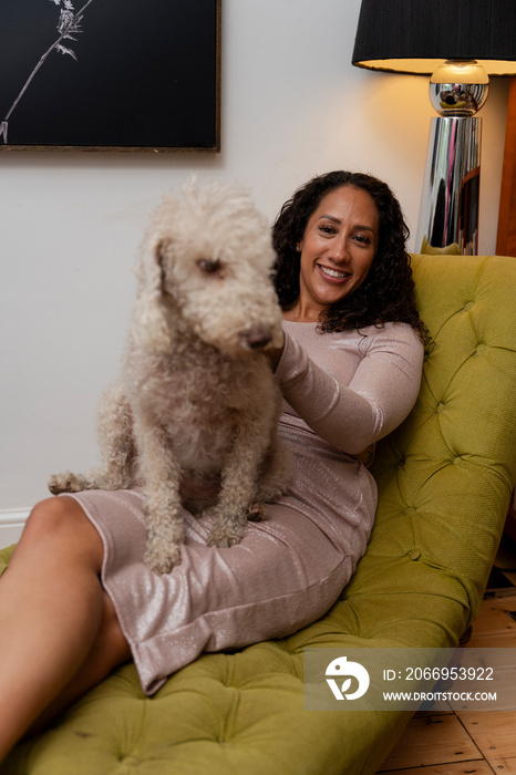 Woman sitting with bedlington terrier on her lap