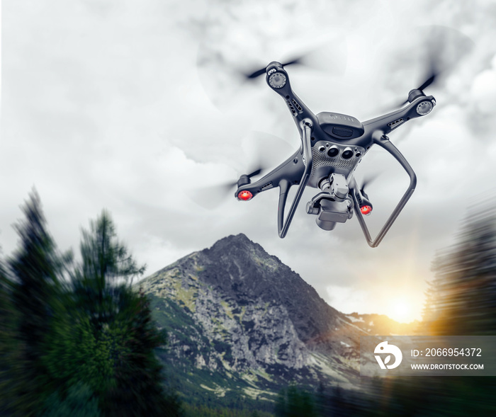 Dark drone in the air against the backdrop of a mountain landscape.