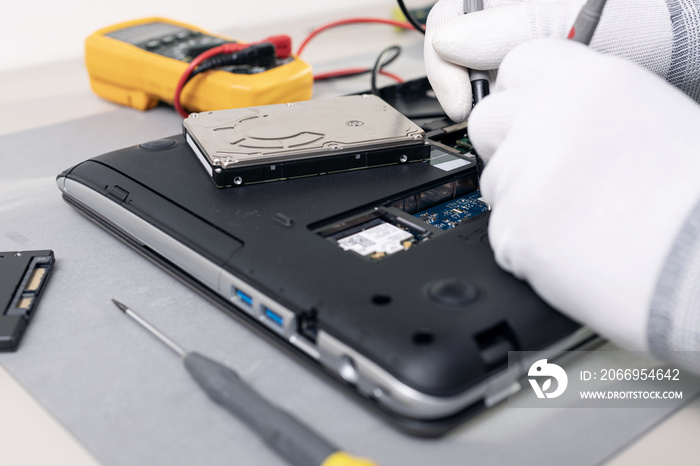 Technician hands repairing a laptop computer. Close up