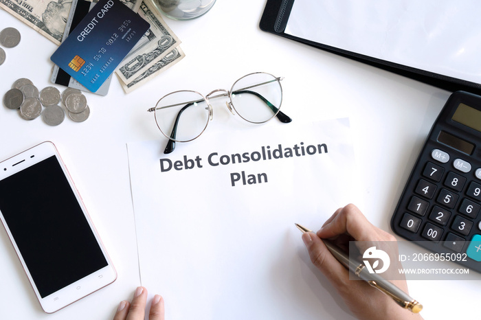 Woman writing debt consolidation plan in paper on desk. Copy space, top view.