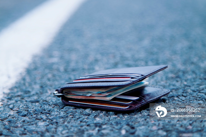 Wallet with money on the road. Wasted time is money lost concept.