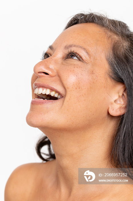 Studio portrait of smiling woman looking up