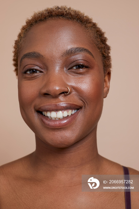 Studio portrait of smiling woman with nose ring