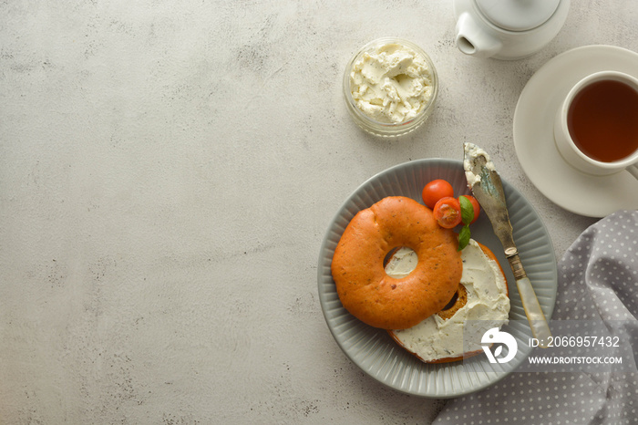 Breakfast with bagels and cheese, cherry, basil, tea cup. Healthy food. Copy space.