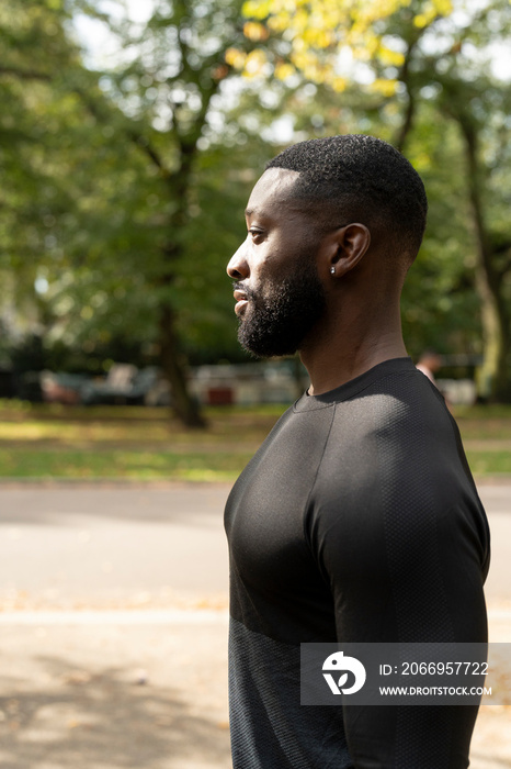 Profile of athletic man standing in park