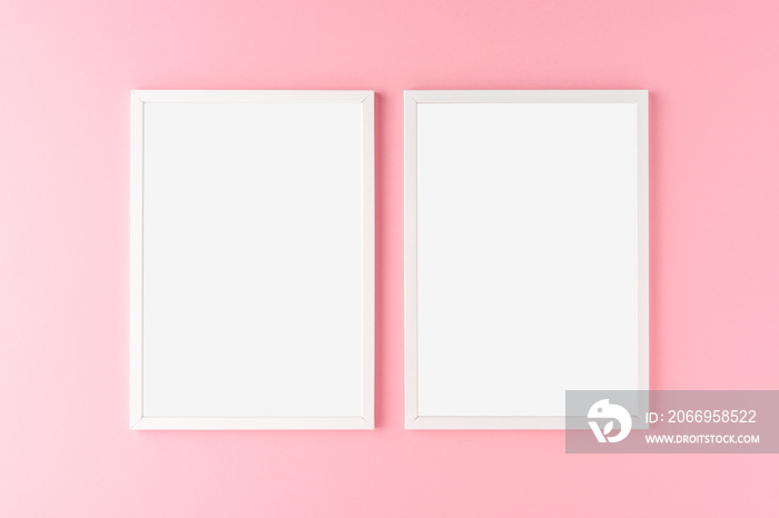 Two white photo frames with copyspace on pink background