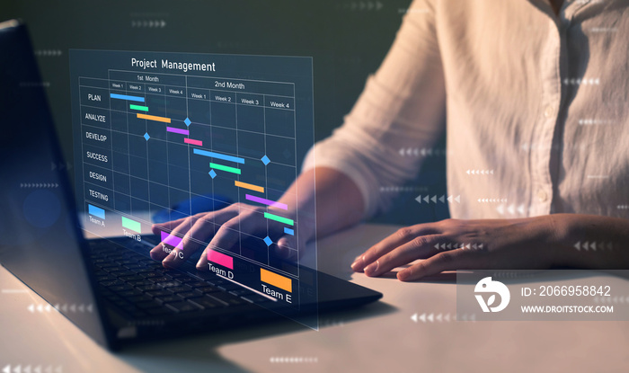 Project manager working on laptop and updating tasks and milestones progress planning with Gantt chart scheduling interface for company on virtual screen. Business Data Management System.