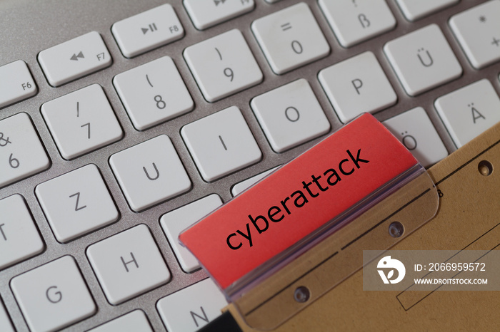 cyberattack as a term on a red tab of a brown hanging file on a computer keyboard