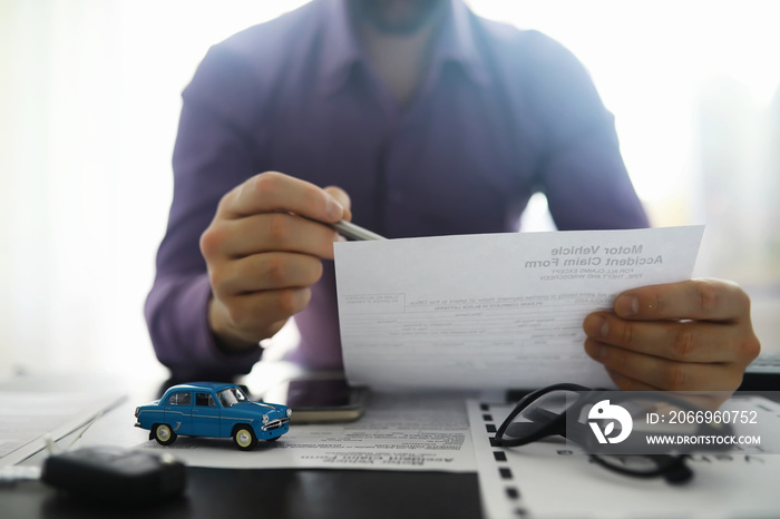 The insurance agent signs a document. Car insurance policy. Auto insurance policy. Forms for registration of the contract.