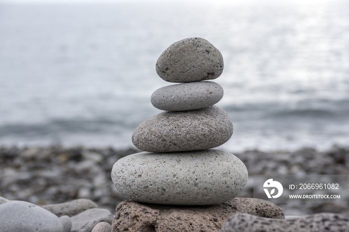 Stone cairn tower, poise stones, rock zen sculpture, light grey pebbles