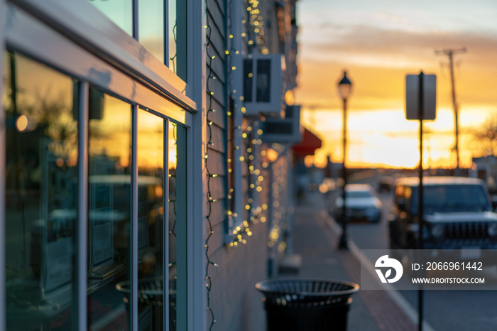 Storefront windows reflecting sunset, small town street, near harbor ocean