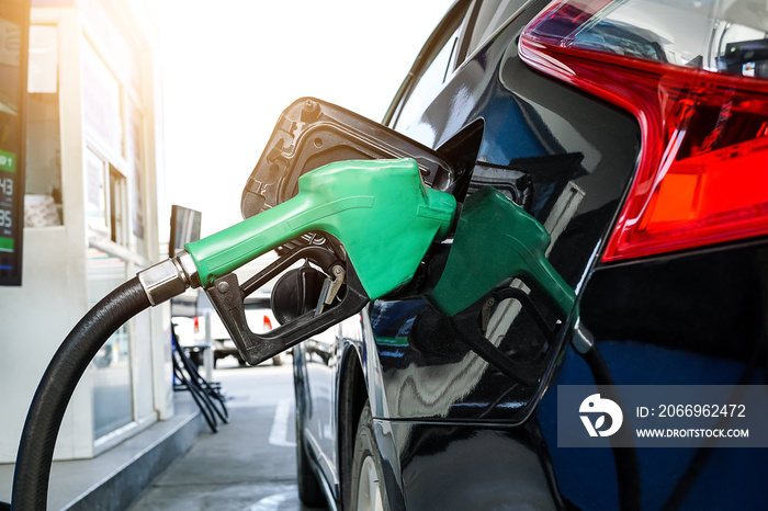 Close up of the fuel nozzle refueling car at the gas station.